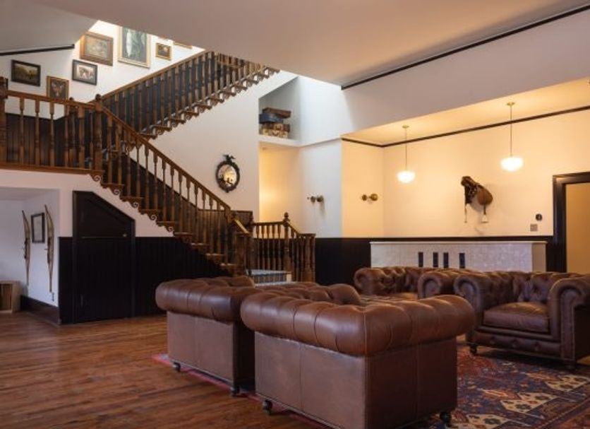 Hotel Hardware Dayton lounge with leather sofas, grand staircase, and hardwood floors