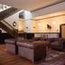 Hotel Hardware Dayton lounge with leather sofas, grand staircase, and hardwood floors