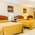 Gran Hotel Paris in La Ceiba: guest room with three twin beds, bedside lamps, and curtains