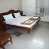 Hotel Sunil Krishna in Tirupati guest room with double bed, TV, chairs, and tray tables
