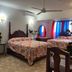 Villa Antonia 16 in Sosúa: twin beds in a colorful guest room with ceiling fan and window seating
