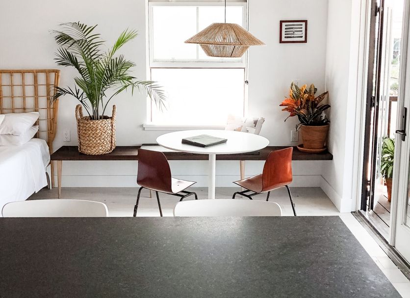 Lokal Hotel Cape May room with lofted ceiling, round table, chairs, large pendant lights and plants