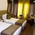 Hotel Centre Point Nagpur guest room with two twin beds and bright curtains by the window