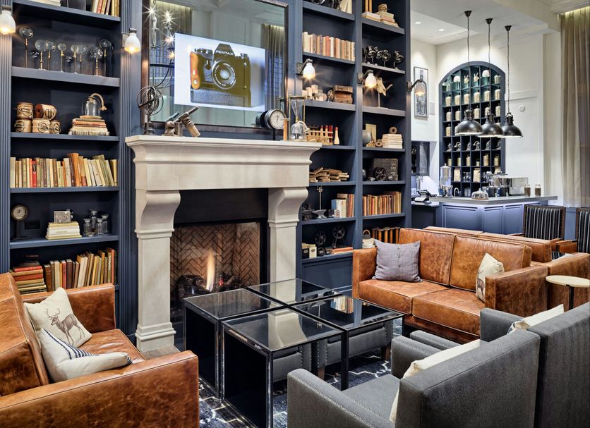 Hotel Teatro Denver lobby with fireplace, leather sofas, and library shelves