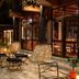 The Deer Park Hotel in Giritale: outdoor patio with tables, chairs and warm-lit glass-fronted building