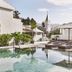Nobu Hotel Marbella pool terrace with loungers, umbrellas, and a church spire in Marbella