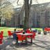 Bitter en Zoet in Veenhuizen, outdoor patio with red tables and chairs beside a historic building