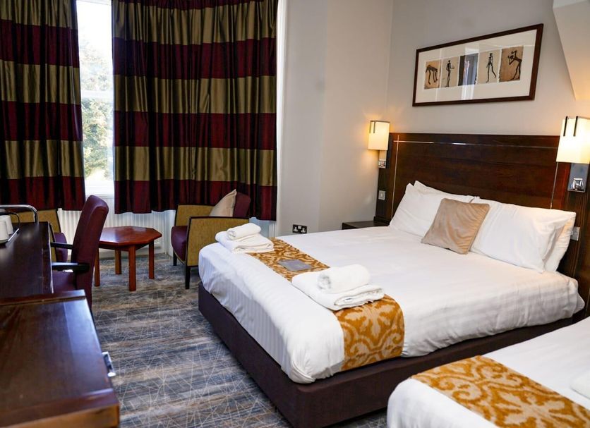 New Wilmington Hotel Eastbourne guest room with double bed, desk, seating area and large windows