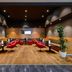 Mövenpick Hotel Egerkingen lounge with red chairs, wood flooring, and a small bar area