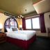 Mcmenamins Elks Temple room in Tacoma with arched headboard, king bed, twin lamps and large window