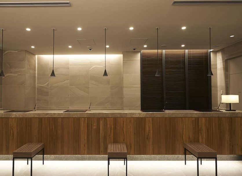 Sotetsu Fresa Inn Ginza-Nanachome lobby with wooden front desk and pendant lights in Tokyo