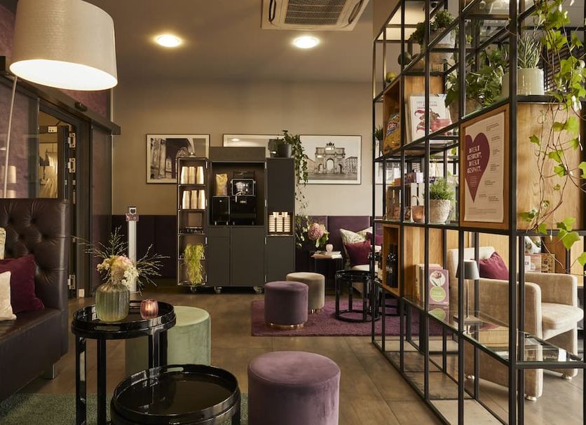 Mirabell München lobby lounge in Munich with purple seating, shelving, and warm ambient lighting