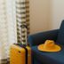 Hotel Del Golfo in Finale Ligure: yellow suitcase and hat beside a blue sofa by sheer curtains