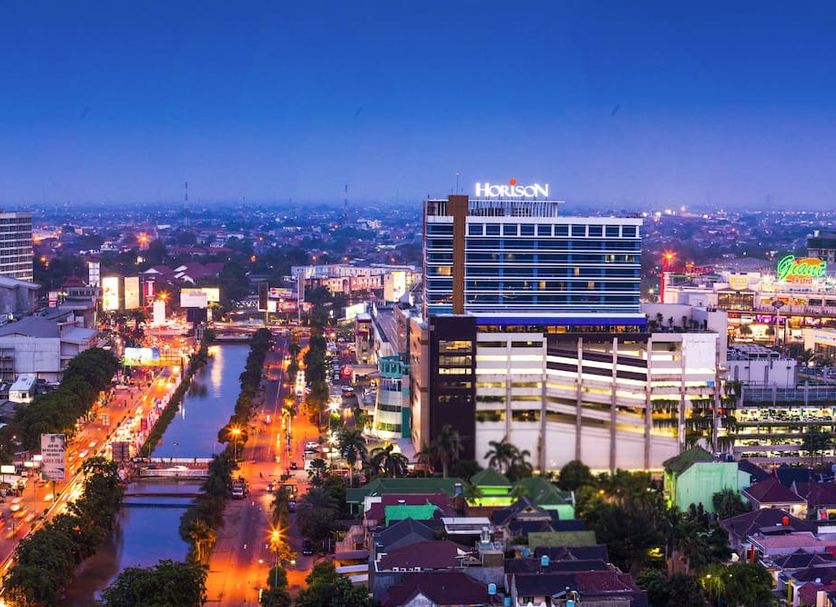 Horison Ultima Bekasi skyline view with a city canal, busy streets, and lit buildings at dusk