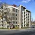 Solo Suites in Victoria, modern hotel exterior at a street corner with balconies and leafless trees