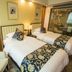 Jinshan Hotel Shanghai guest room with two twin beds, bedside lamp, and glass-walled bathroom