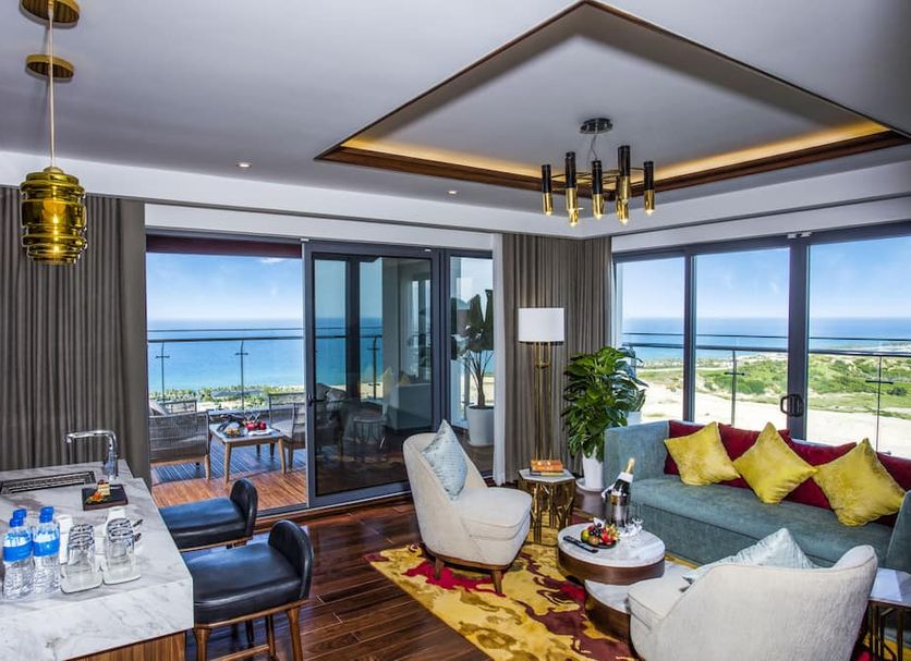 Duyen Ha Resort Cam Ranh suite with ocean-view balcony, floor-to-ceiling windows and seating area in Ấp Vạn Tự Tây