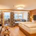 Ferienhotel Sonnenhof in Zell am Ziller: bright suite with balcony, sofa, and double bed