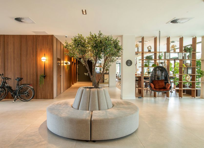 Leonardo Hotel San Sebastián lobby with round sofa, bicycles, and a tree centerpiece in San Sebastián