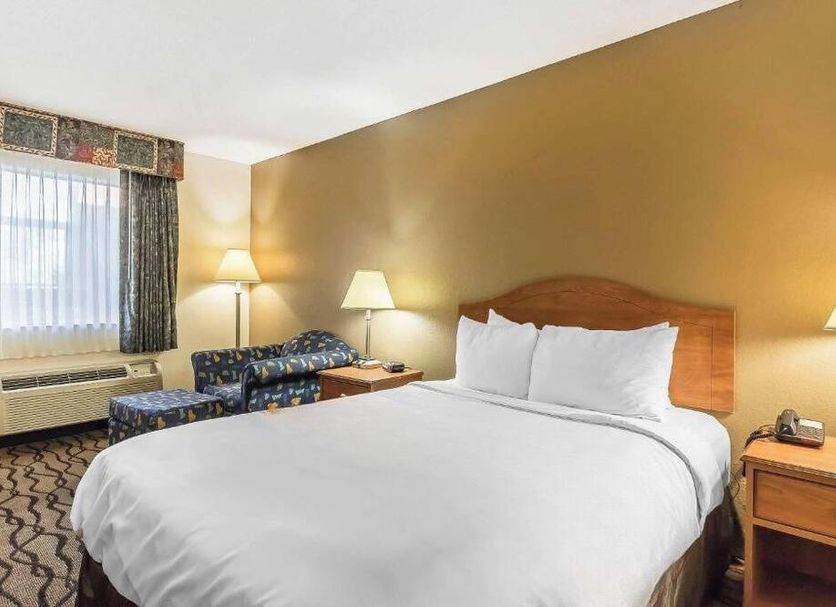 The Riverstone Hotel in Charleston guest room with king bed, armchair, lamps, and window seating