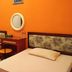 Patria Garden Hotel in Blitar twin guest room with orange walls, two beds, desk and mirror