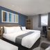 Travelodge London Twickenham guest room with triple beds, desk, window and wardrobe