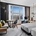 Hilton Munich Airport guest room in Munich with twin beds, seating area, and city view