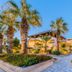 Olive Garden Hotel in Lardos with palm-lined landscaped grounds and a lit walkway at dusk