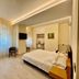 Hotel San Pancrazio in Trescore Balneario bedroom with bed, wall-mounted TV, chair and large window