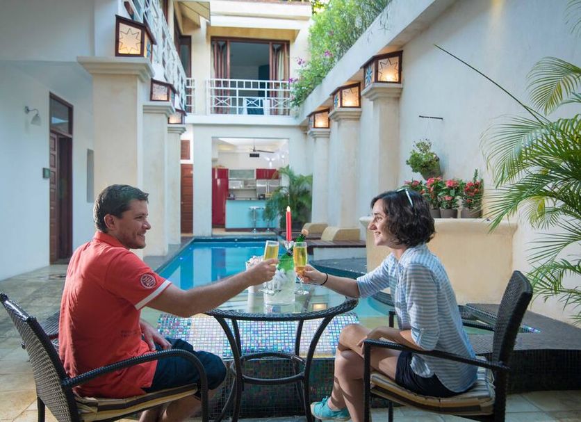 Hotel Boutique Casa Sánchez in Santo Domingo: guests toasting beside the courtyard pool