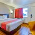 Motel 6 Santa Rosa Nm guest room with king bed, red curtain, and wood-look floor in Santa Rosa