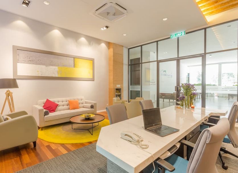 Meru Suites at Meru Valley Resort in Ipoh, modern lounge with seating and worktable by glass doors