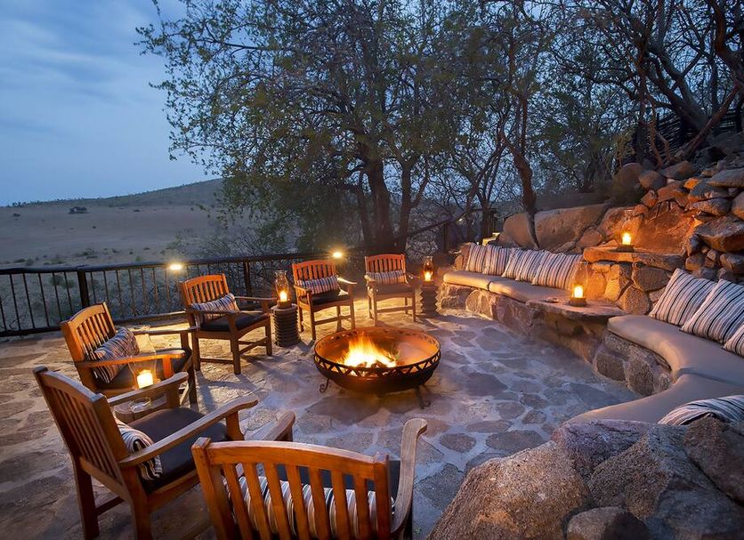 Tshukudu Bush Lodge in Pilanesberg fire pit lounge with curved stone seating and lantern lighting