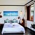 Blue Hill in Victoria guest room with a bed, sailboat wall art, wood wardrobe, and open window