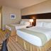 Holiday Inn Express & Suites Las Vegas Sw Springvalley guest room with two beds and bedside lamp