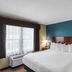 The Hotel Saratoga in Saratoga Springs guest room with king bed, teal accent wall and large window