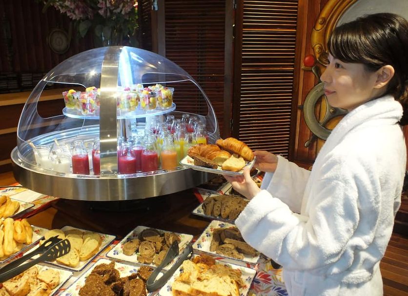 Le Beauséjour in Tregastel buffet breakfast with pastries, fruit drinks and a guest in a robe