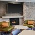 Fairfield Inn & Suites by Marriott Burlington lobby seating area with fireplace and wall-mounted TV