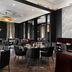 The Warrior Hotel, Autograph Collection in Sioux City dining room with black chairs and dark walls