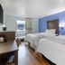 SureStay Plus by Best Western Niagara Falls East room with two beds, blue accent wall, and window view