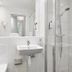 Ikea Hotell in Älmhult bathroom with walk-in shower, sink, and tiled walls