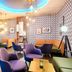 Leonardo Hotel Wolfsburg City Center lounge in Wolfsburg with blue chairs and patterned wallpaper