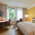 Flottwell Berlin Hotel room in Berlin with double bed, desk, and large window view
