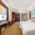 Haili Garden Hotel Guangzhou guest room with two twin beds, desk, and beach wall art