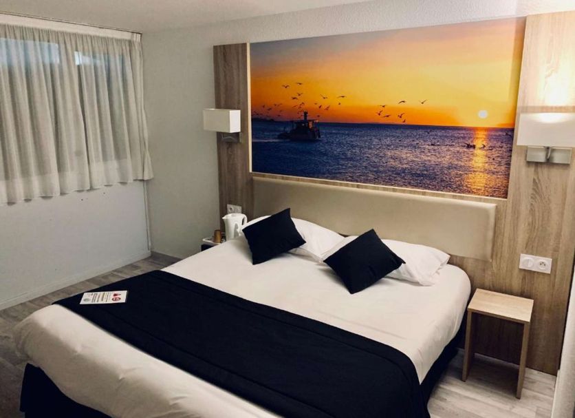 Brit Hotel Confort Morlaix room with double bed and sunset seascape wall art in Saint-Martin-des-Champs