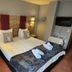 Hotel Buckelhof in Landeck guest room with twin beds, wall-mounted TV, and bedside lamps