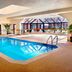 Indoor pool at Sonesta Select Boston Foxborough Mansfield in Foxborough with large skylight and lounge chairs