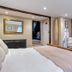 The Grove Cromer bedroom with fireplace, wall-mounted TV, and ensuite bathroom doorway in Cromer