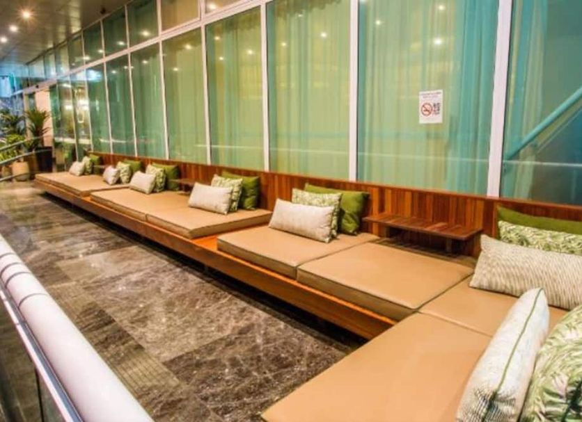 Royal Macaé Palace Hotel lounge seating with long cushioned bench and glass wall in Macaé