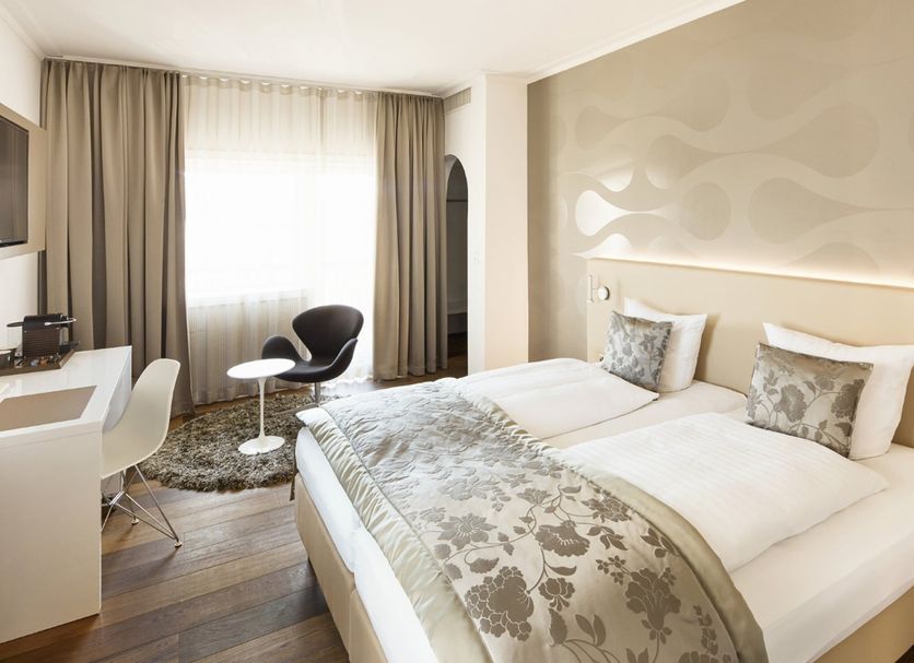 Hotel Uzwil in Uzwil: modern guest room with twin beds, desk, chair and large window with curtains